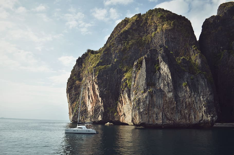 White Sailing Boat Beside Mountain, asia, cliff, clouds, coast HD wallpaper