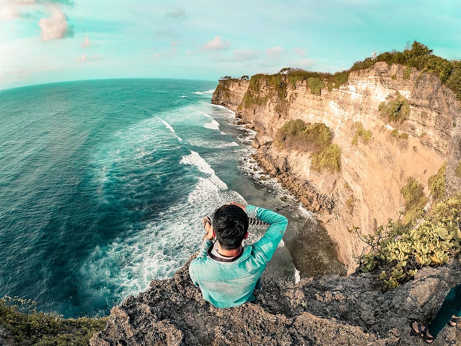 Man Wearing Blue Long Sleeve Top On Top Of Mountain Near Body Of Water HD wallpaper