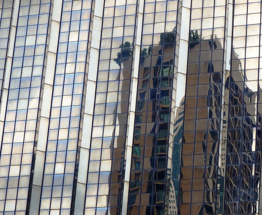 Abstract high-rise building reflection in the glass facade of a modern skyscraper HD wallpaper