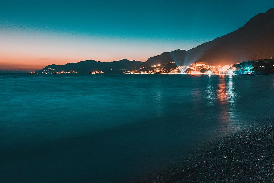 Calm Body of Water Facing Lighted City Near Mountain, beach, evening HD wallpaper