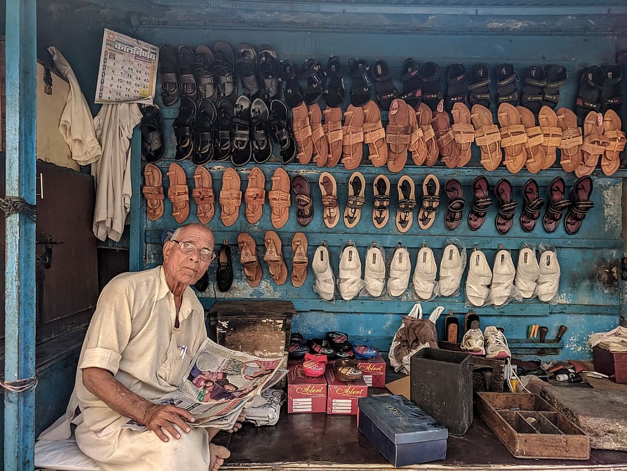 Man Reading Newspaper Surrounded by Shoes, adult, art, business