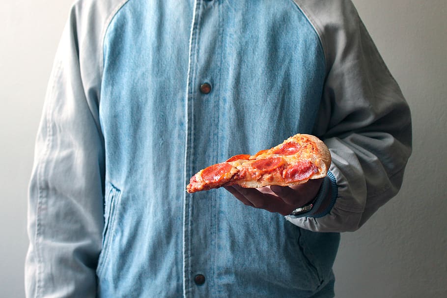 person holding slice pizza, apparel, clothing, sleeve, long sleeve
