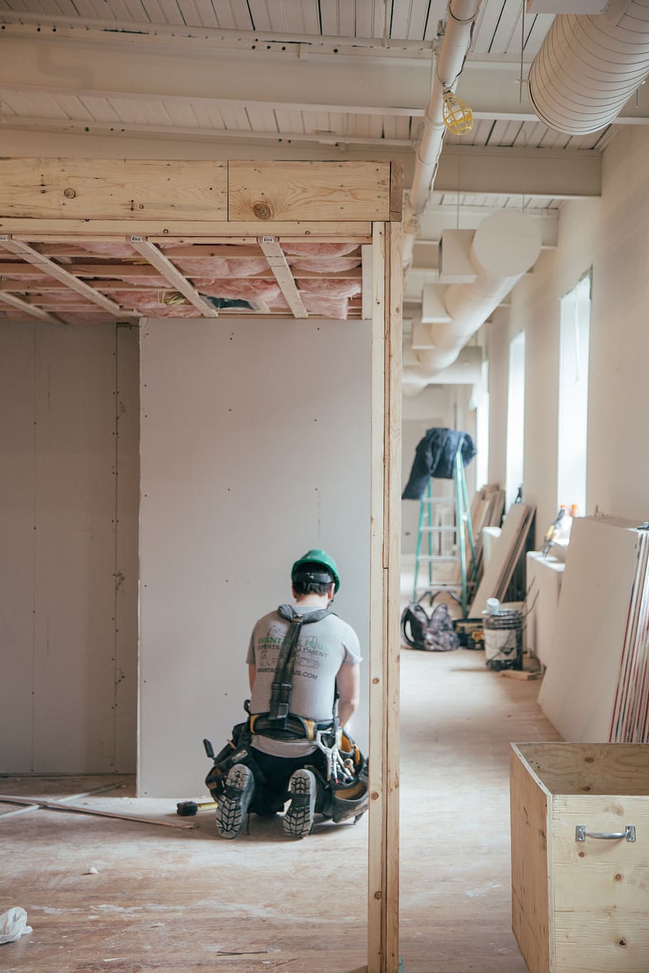 man kneeling in front of wall, wood, furniture, chair, plywood