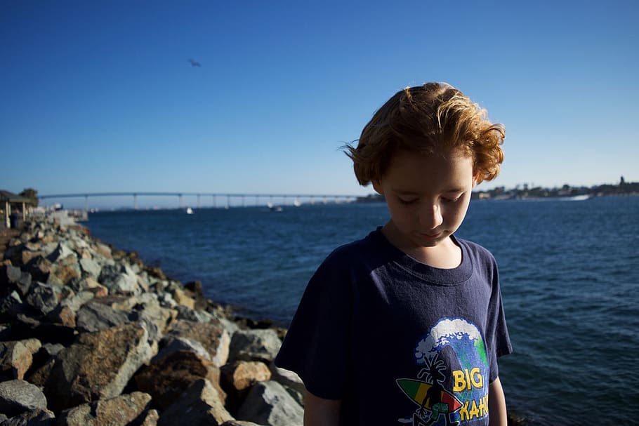 boy standing on rocking shore while looking down, clothing, apparel HD wallpaper