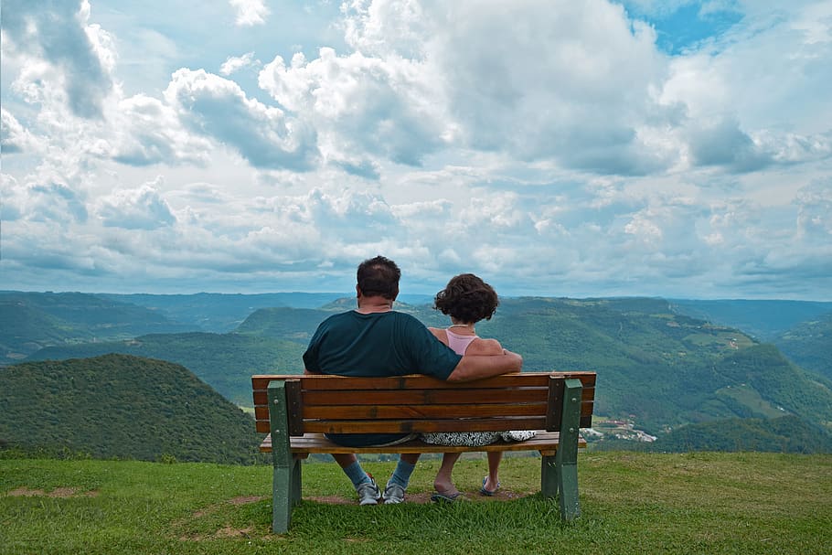Couple Sitting on Brown Wooden Bench Near Mountains Covered With Grasses Under Blue Cloudy Sky, HD wallpaper
