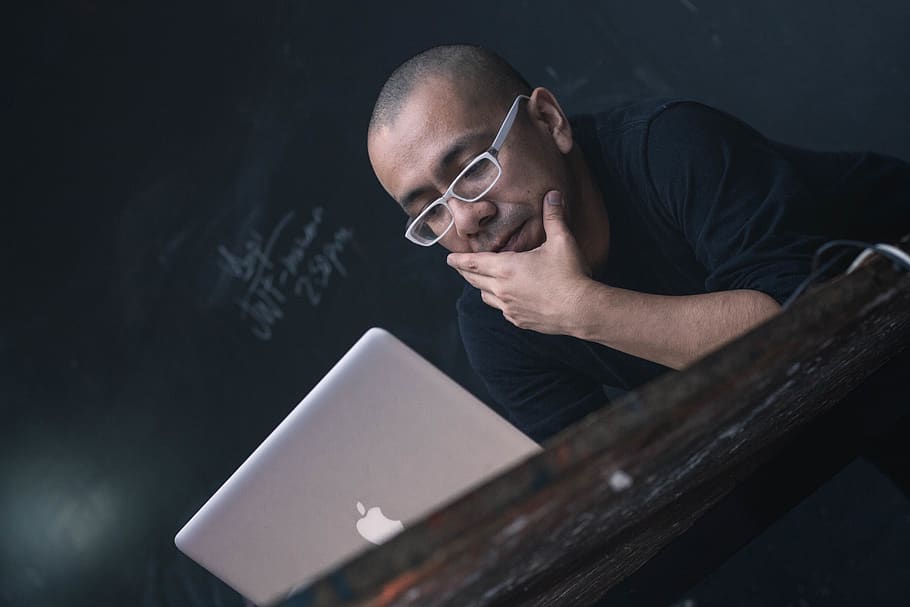 man using silver MacBook, one person, men, adult, shaved head HD wallpaper