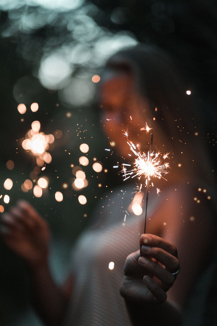 woman holding fire cracker in selective focus photography, sparkler