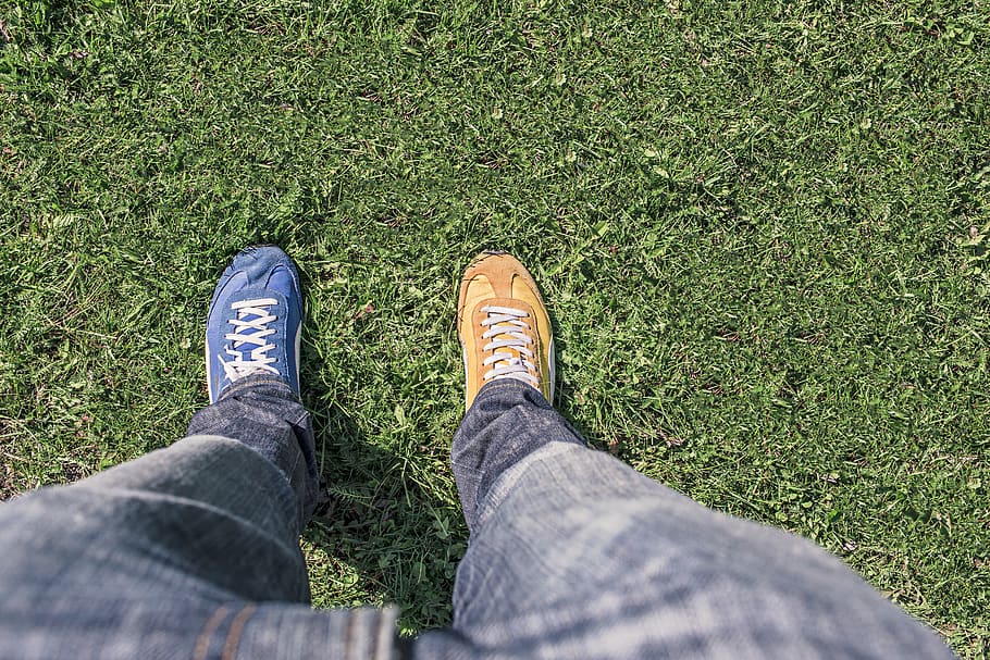 Person Wearing Unpaired Running Shoes Standing on Green Grass HD wallpaper