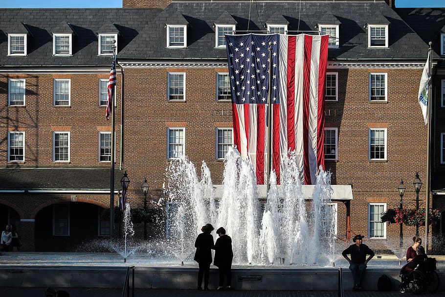 Old brick administration building with large American flag hanging in Alexandria, Virginia.