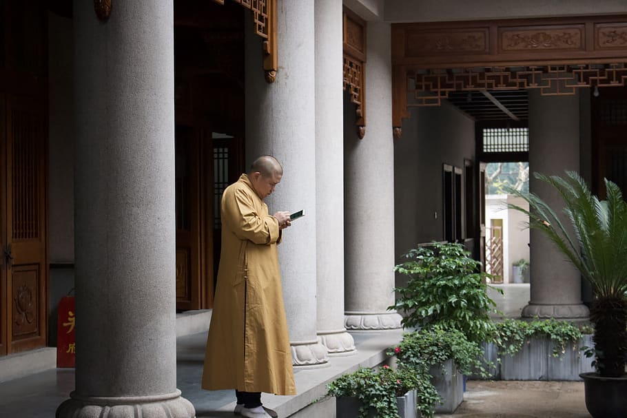 man using Android smartphone in temple, apparel, clothing, coat HD wallpaper