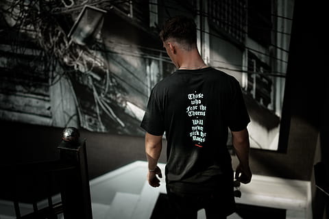 man in black crew-neck T-shirt looking down on white stair, text HD wallpaper