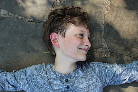 boy lying on concrete pavement smiling, human, person, face, clothing HD wallpaper