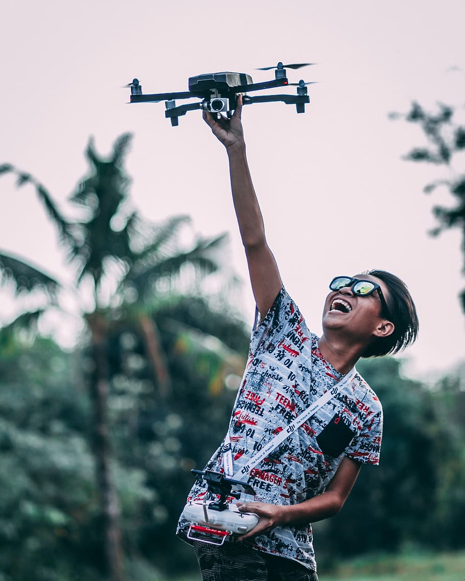 Man Holding Quadcopter Drone With Controller, active, aircraft HD wallpaper
