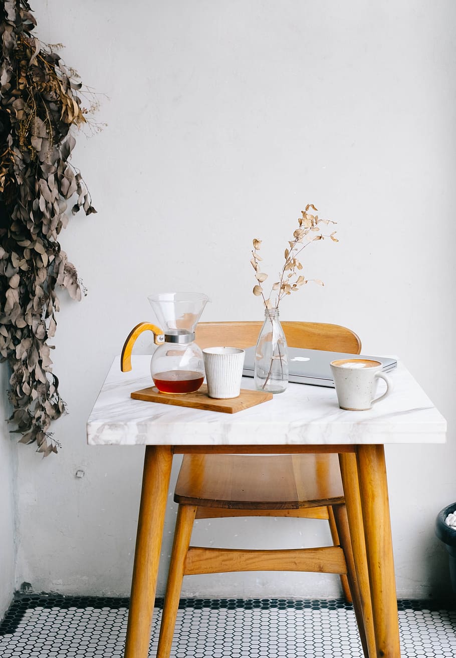 white ceramic mugs, clear glass pitcher and vase, and silver MacBook on top of white and brown table HD wallpaper