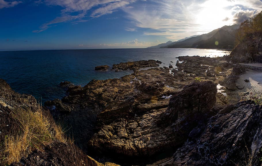 Mountain Range Near Body of Water, beach, ocean, rocks, sky, sun HD wallpaper