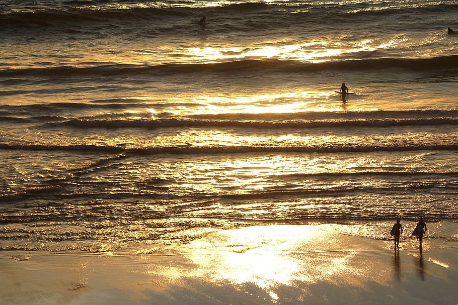 surfers, beach, reflection, evening, sunset, silhouette, sand HD wallpaper