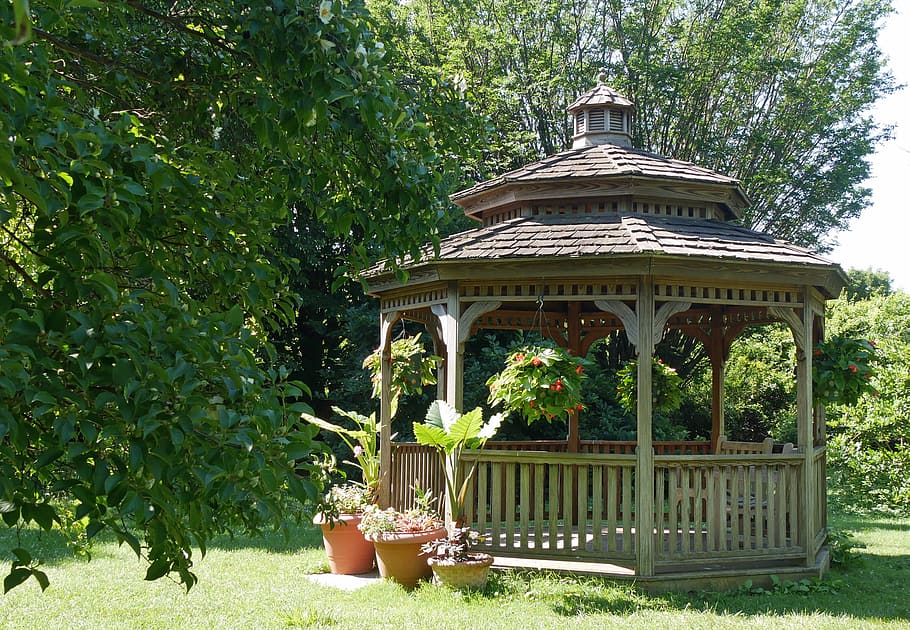 A small wooden gazebo in a backyard garden., outdoor gazebo, small gazebo
