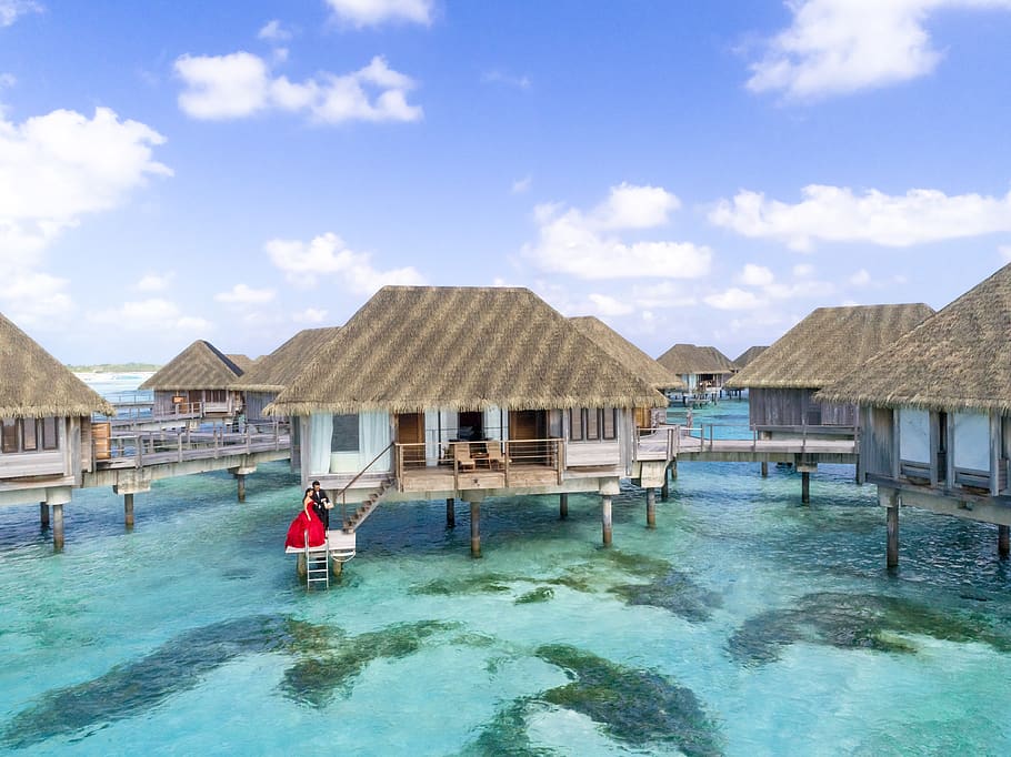 Cluster of Beige Huts Above Water, beach, clouds, couple, daylight HD wallpaper