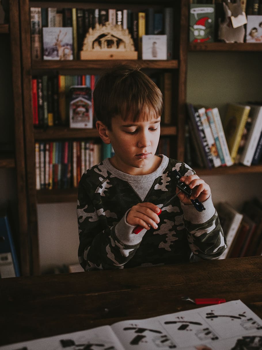 boy behind table, furniture, bookcase, shelf, human, person, couch HD wallpaper