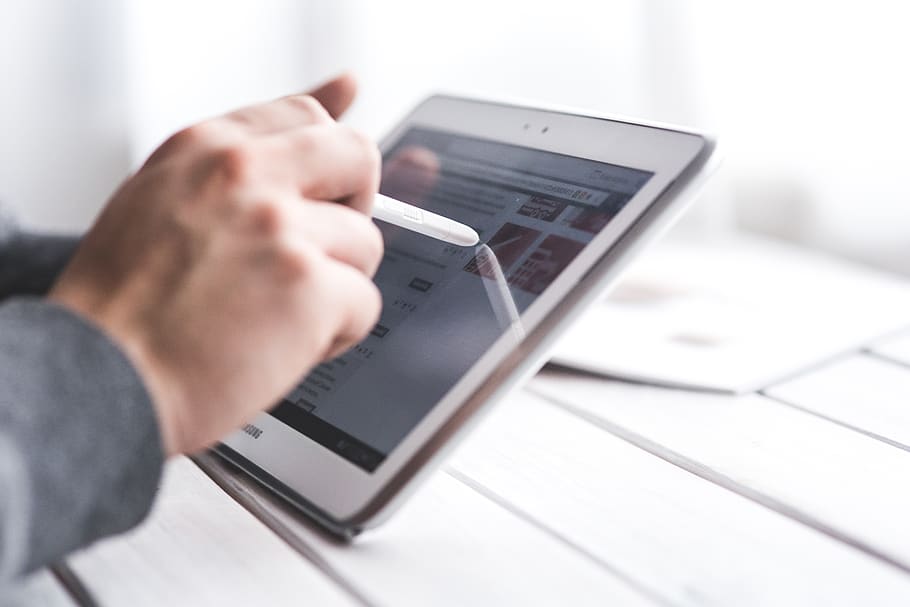 Hand using stylus pen for touching the digital tablet screen HD wallpaper