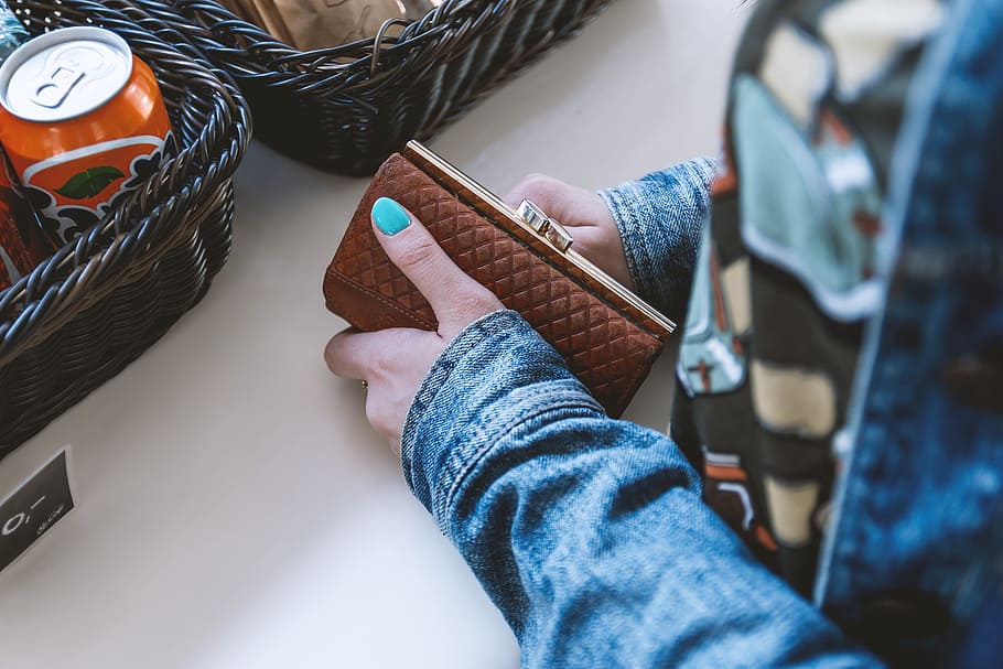 Woman at the checkout with her fashion wallet in hand, one person HD wallpaper