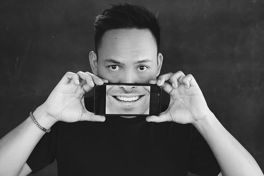 man holding smartphone, portrait, looking at camera, front view HD wallpaper