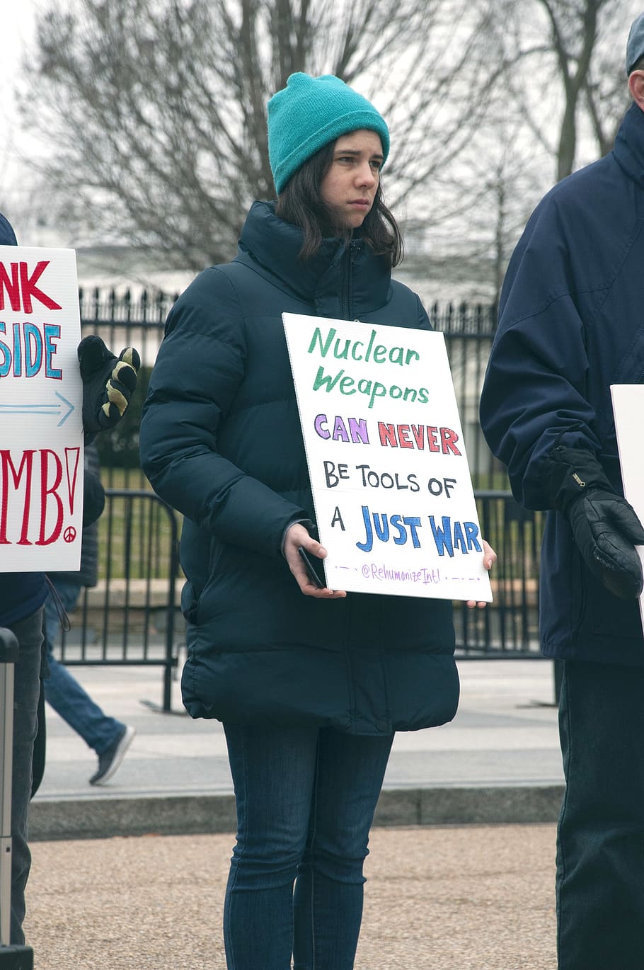 woman holding signage near green leaf trees, apparel, clothing, HD wallpaper