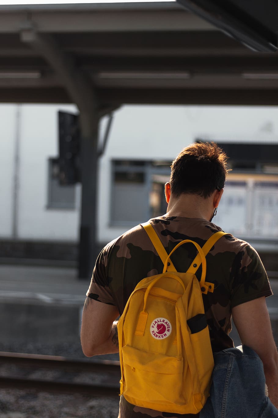 man carrying yellow backpack in train station, real people, one person HD wallpaper