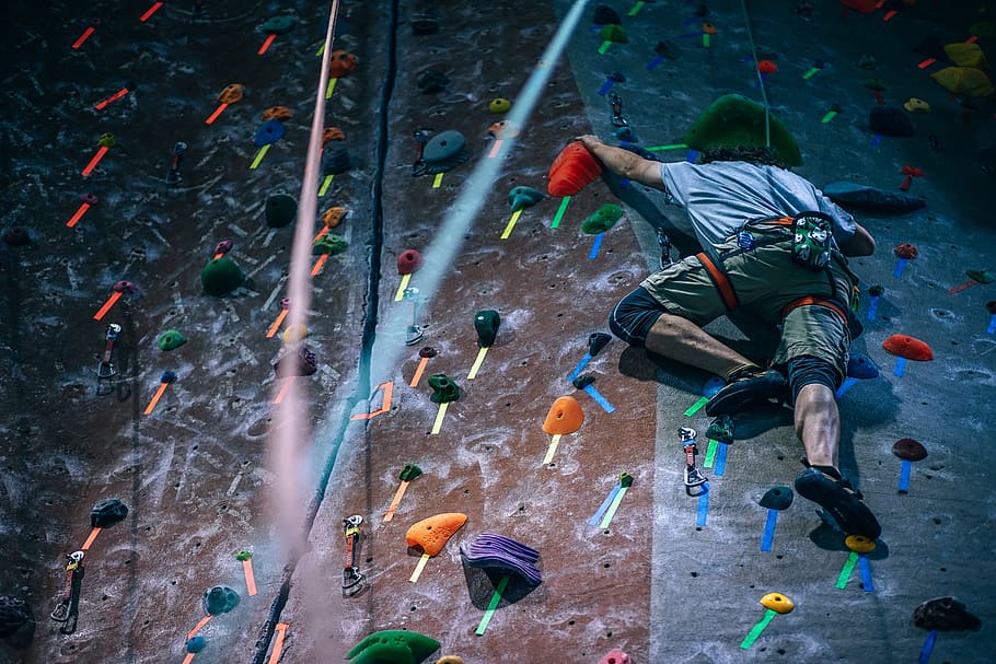man climbing wall with harness, extreme sports, rock climbing