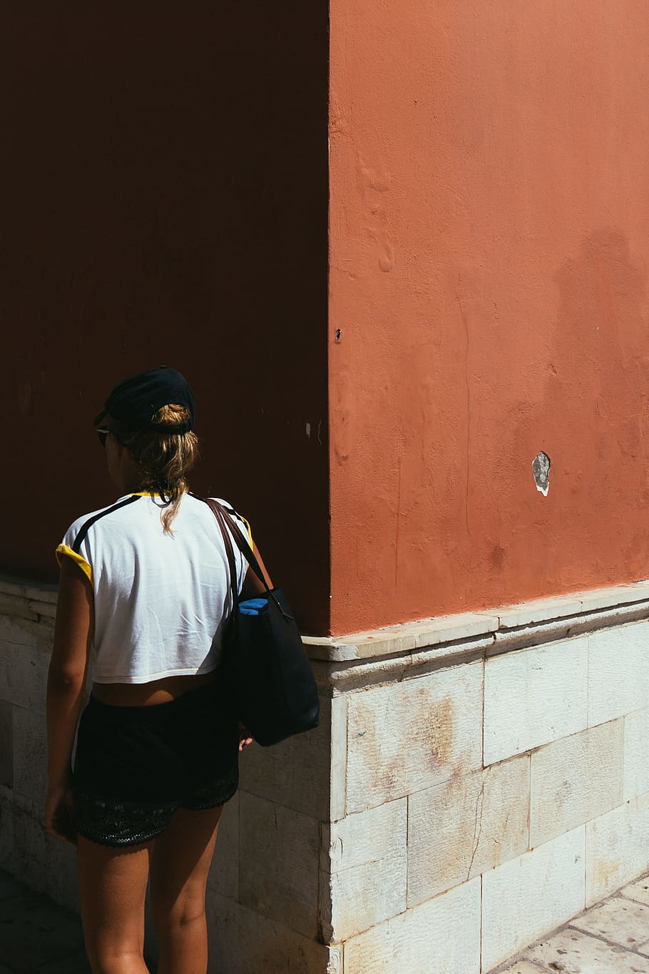 woman facing wall, shadow, person, standing, urban, corner, hat HD wallpaper