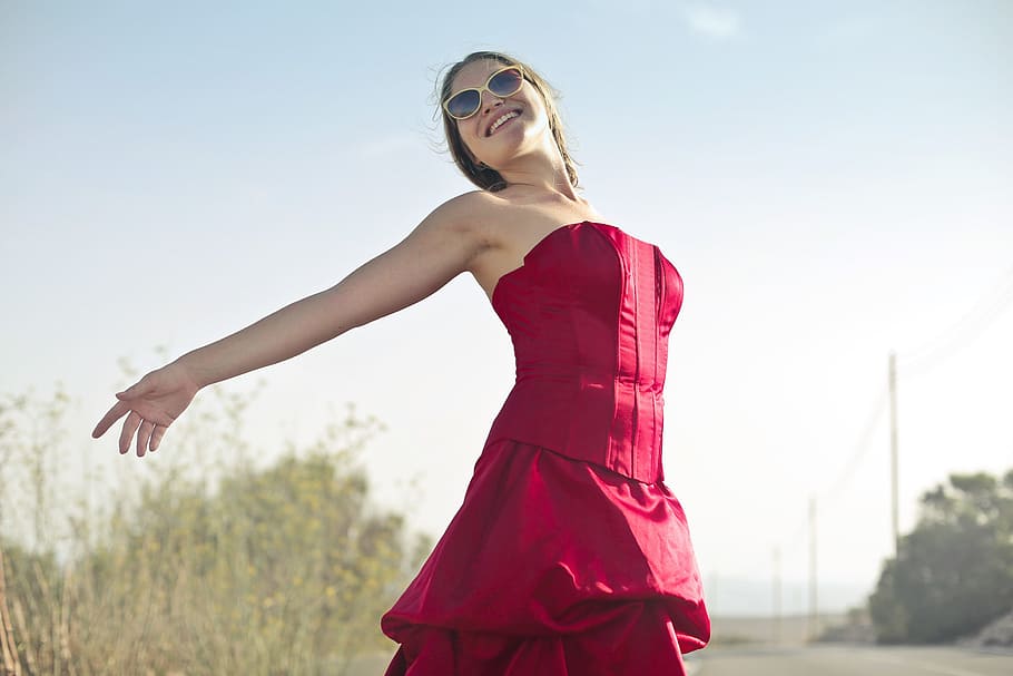 Young Adult Woman In Red Party Gown Dress And Sunglasses During Outdoor Photo shoot