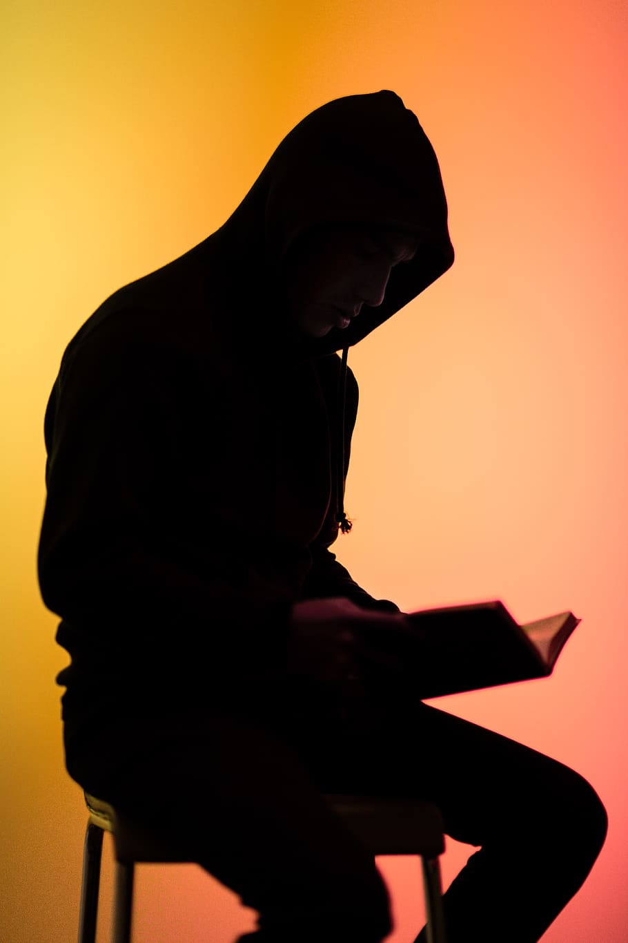 Silhouette Photo Of Person Sitting On Chair While Reading, backlit HD wallpaper