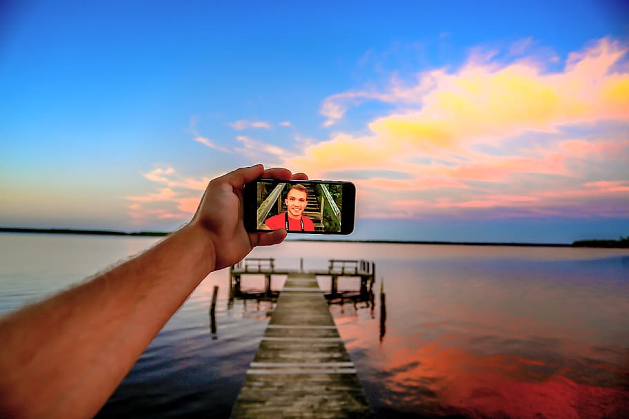 water, sky, photography themes, holding, sea, sunset, technology HD wallpaper