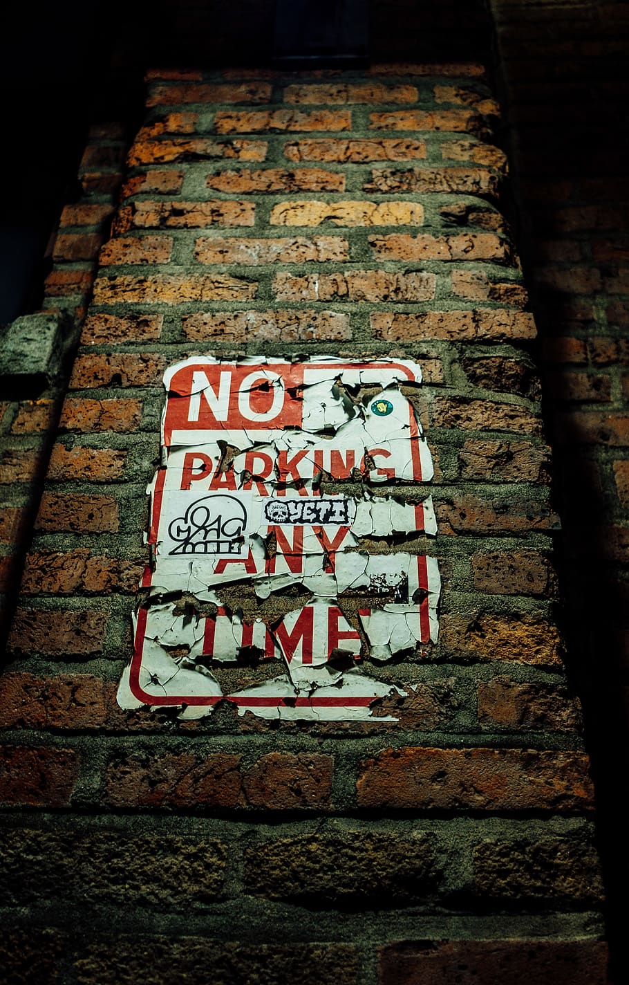 No Parking Any Time sign on wall, brick, path, walkway, text