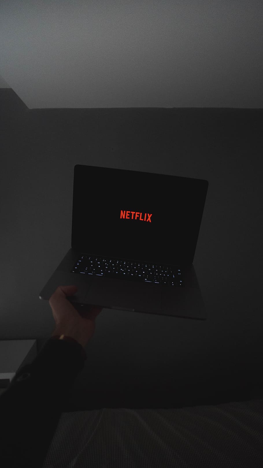 person holding black laptop computer, netflix, logo, keyboard