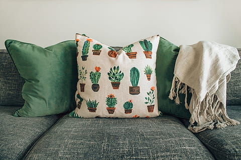 three throw pillows and one white fringed blanket placed on top of gray sofa HD wallpaper