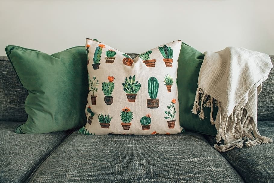 three throw pillows and one white fringed blanket placed on top of gray sofa HD wallpaper