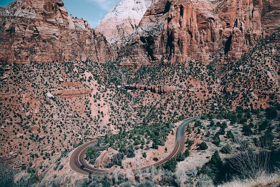 Route 66 winding through grand canyon surrounnded by peaks and trees HD wallpaper