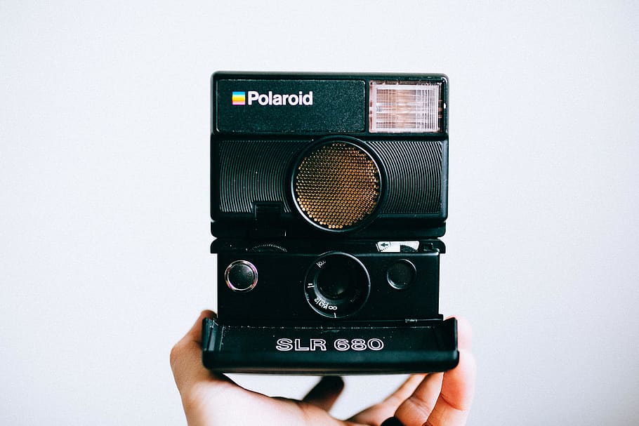 person holding black Polaroid SLR 680 instant camera, electronics, HD wallpaper