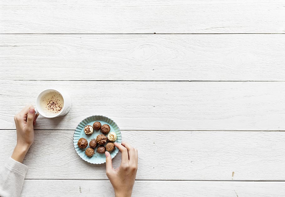 Person Holding White Ceramic Mug on White Wooden Table, chocolates HD wallpaper