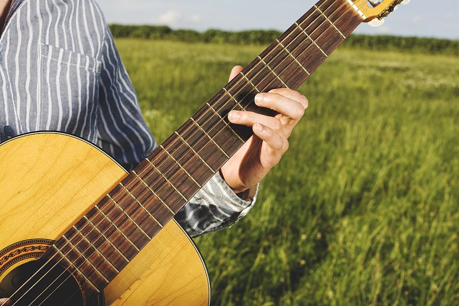 Person Playing Guitar in Grass Field, bowed stringed instrument HD wallpaper