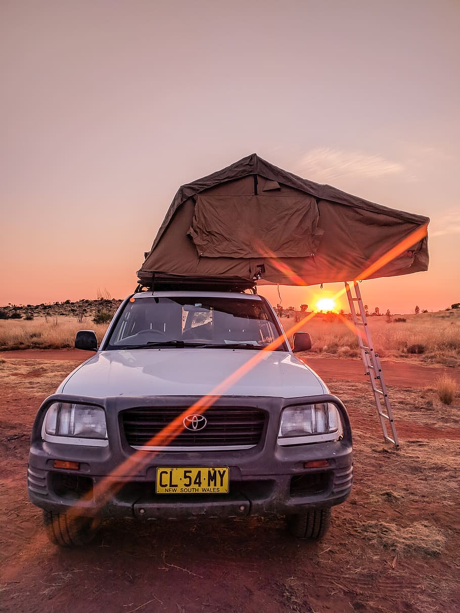 white-toyota-car-parked-under-orange-sun