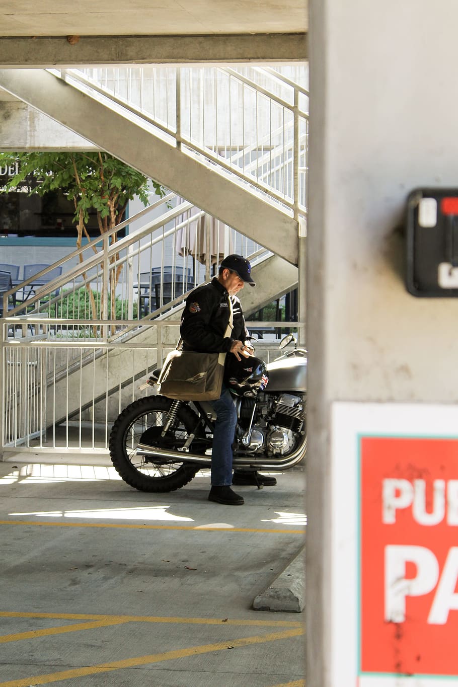 man riding on motorcycle, downtown, sign, bright, parking garage HD wallpaper
