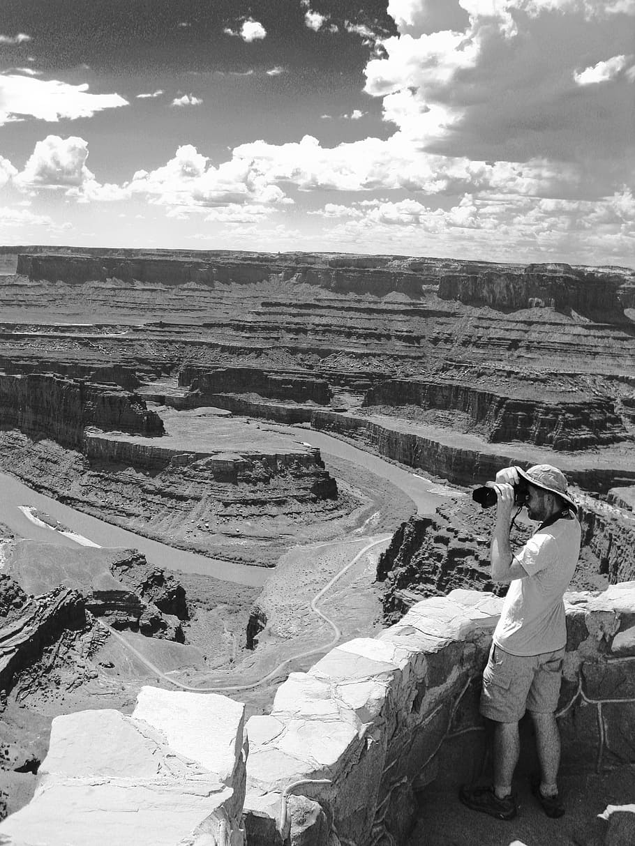 Man Standing Holding Camera Near Grand Canyon Grayscale Photo HD wallpaper
