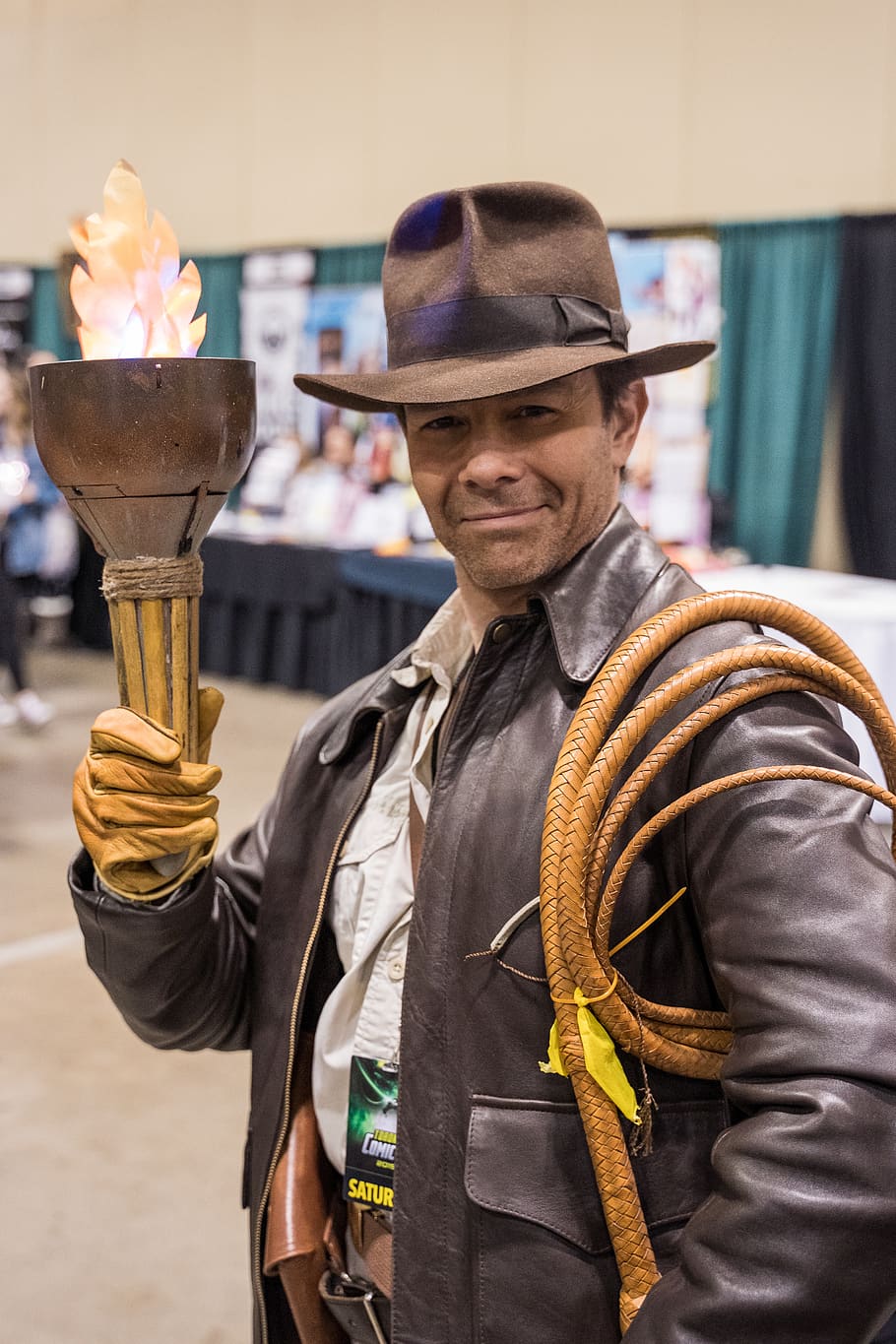 man in brown hat and jacket holding torch, apparel, clothing