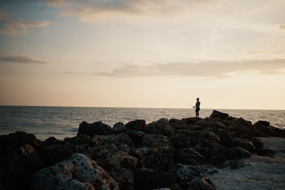 Person Standing on Rocky Shore, beach, clouds, dawn, evening HD wallpaper