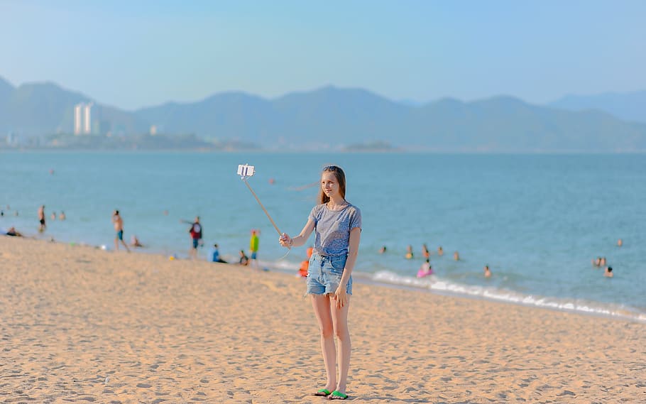 Woman Standing on Seashore Taking Selfie Using Monopod at Daytime, HD wallpaper