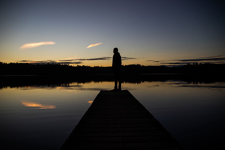 Silhouette of Person Standing on Body of Water Dock during Sunrise HD wallpaper
