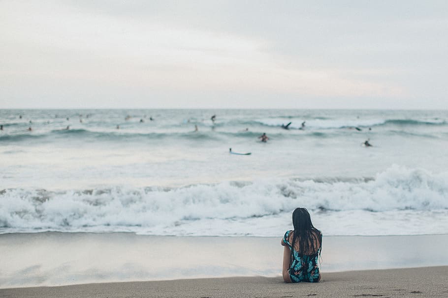 Woman Sitting at Shore, back view, beach, blur, coast, depth of field HD wallpaper