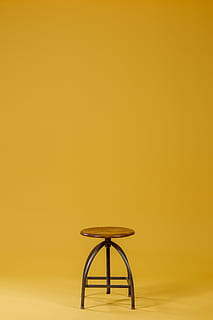 HD wallpaper: round brown wooden top and black base chair on yellow  background | Wallpaper Flare
